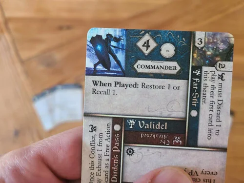 A hand holding Denizens cards, the Commander card Validel on top.